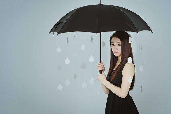 悲伤的女孩与一个黑色的伞在雨中