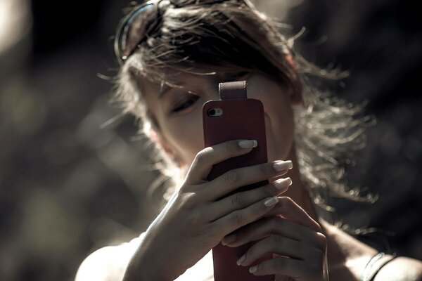 A girl with a phone in her hands poses