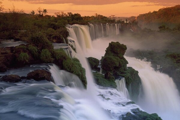 The waterfall flows into a mountain river