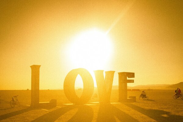 The inscription love on the background of sunset