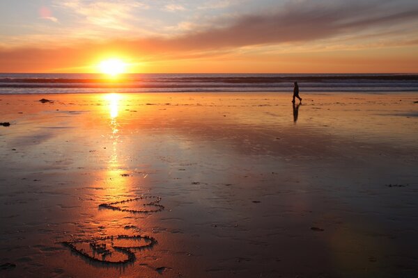 Brillante puesta de sol en la playa de arena