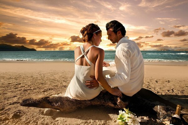 Lovers on the beach against the sunset