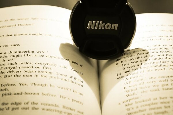 Camera lens cap on an open book