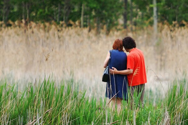 A man and a woman walking in a field