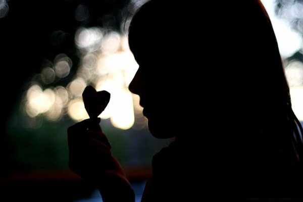 Misteriosa mujer con el corazón en la mano