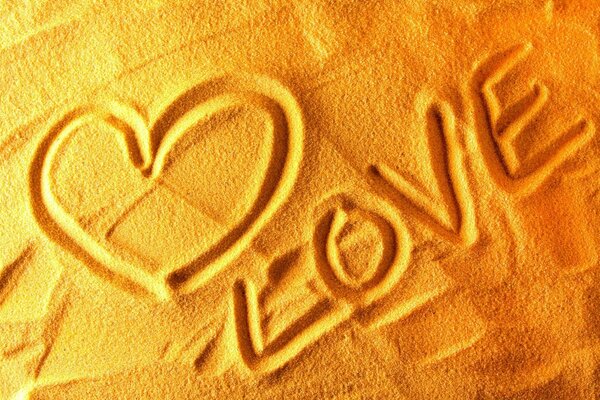 Das Wort Liebe und Herz im Sand