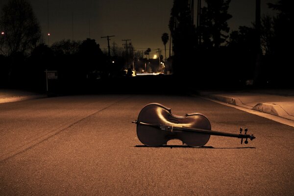 Violin on the road under the light of a lantern