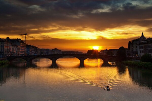 Réflexion du pont dans les eaux du coucher du soleil de la rivière