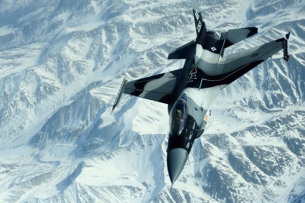 A plane flying over snow - white mountains