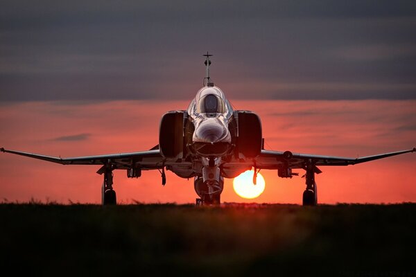 Avion debout militaire au coucher du soleil