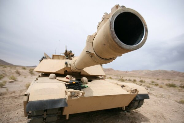 In the desert, the barrel of a tank is looking at you