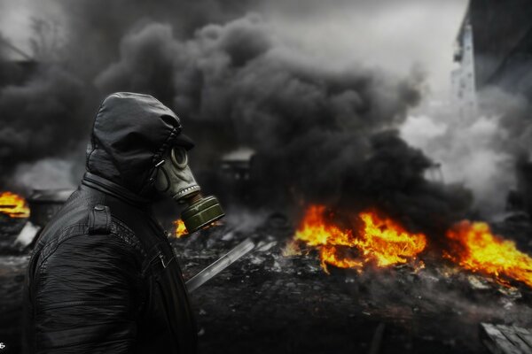 Natural disaster fire on the background of black smoke with a man in a gas mask