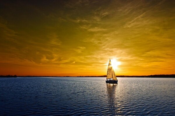 Yate en una superficie de agua tranquila. Puesta de sol, noche