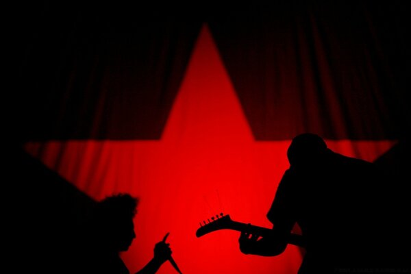 Dúo de músicos en el fondo de una estrella roja