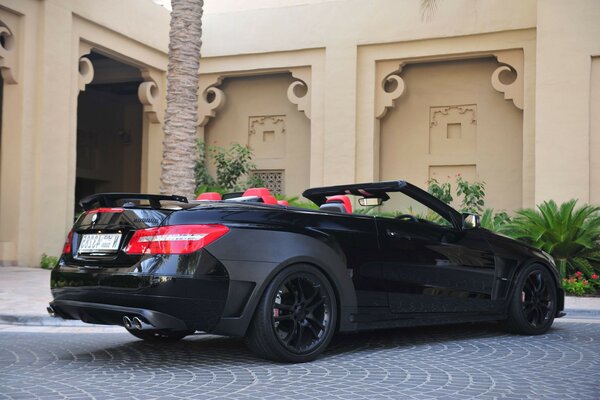 A black car with black wheels is parked