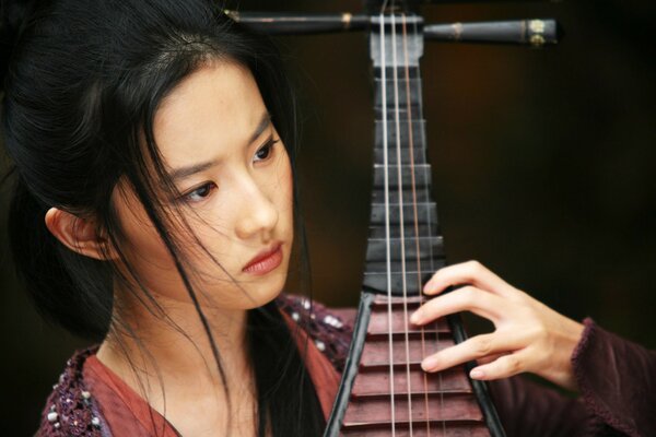 Beautiful young girl with a musical instrument