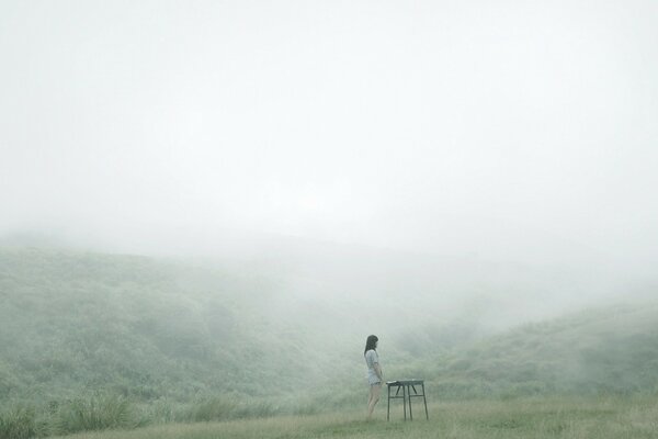 A girl in a fog on a mountain in summer