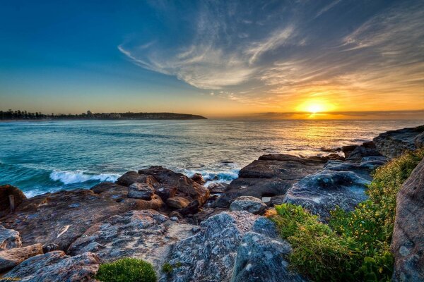 Pôr do sol em uma praia inóspita e rochosa