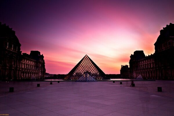 The famous Louvre Museum in Paris on the background of a pink sunset without crowds of tourists