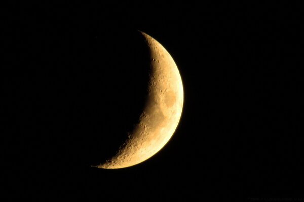 A bright crescent moon on a black background