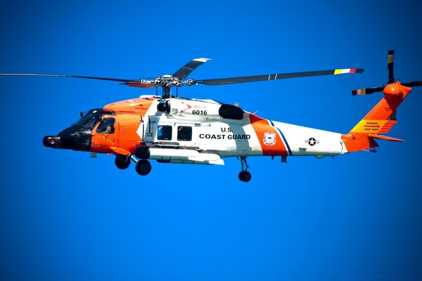 A bright white-orange helicopter hovered in the air