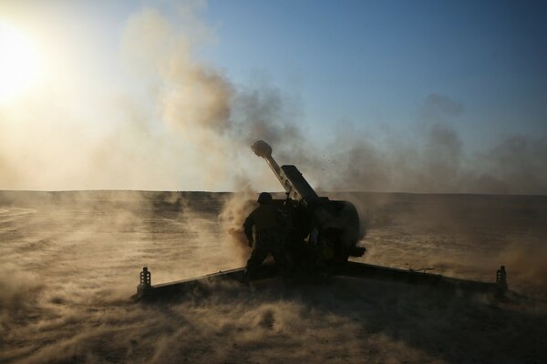 An artillery piece against a background of black smoke