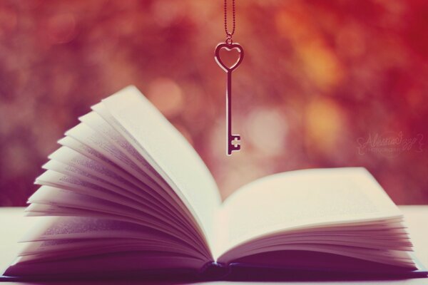 Image of an open book with a key hanging over the book