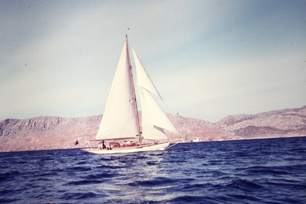 Sailboat in the sea on the background of hills