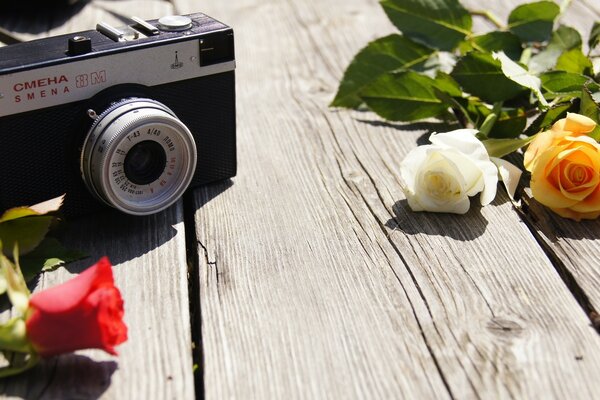 Vintage-Kamera und Rosen auf dem Tisch