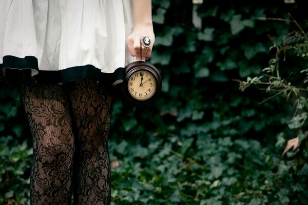 The girl with the clock in the forest