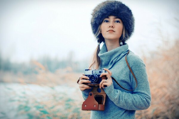 Donna in un cappello e con una macchina fotografica in mano