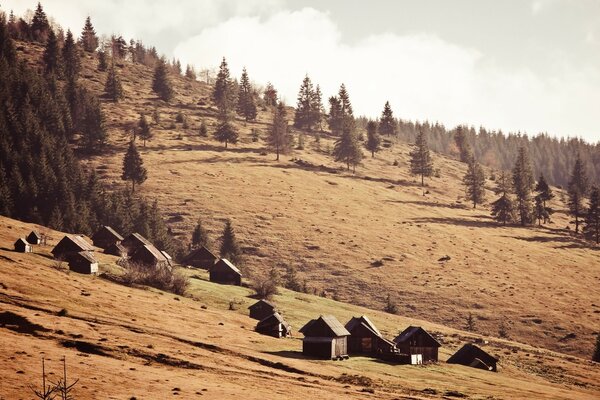 Casas en las montañas bajo la ladera Vintage