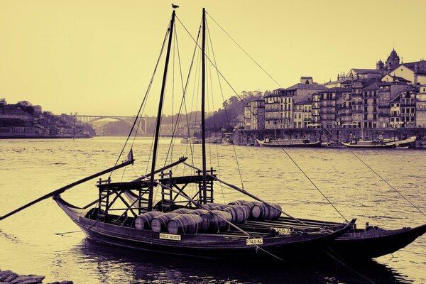 Una vieja foto en blanco y negro de un barco en el fondo de la ciudad