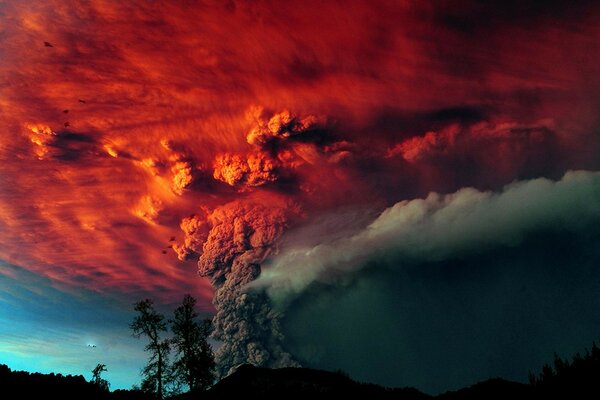 Vulcano eruzione alberi cenere cielo rosso