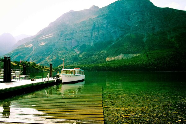 Ein Fluss mit einem Boot. Berge und Sonne