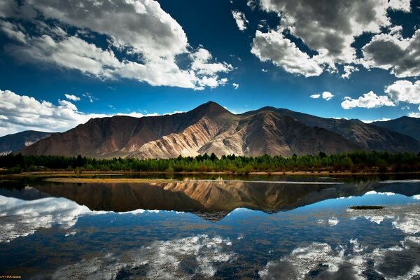 El hermoso lago refleja las montañas y el cielo despejado