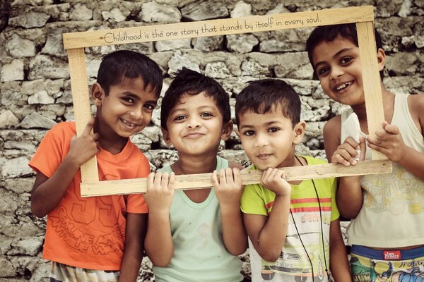 Cuatro niños enmarcados cerca de la pared