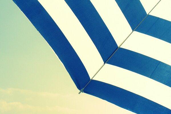 The edge of a vintage umbrella on the beach background