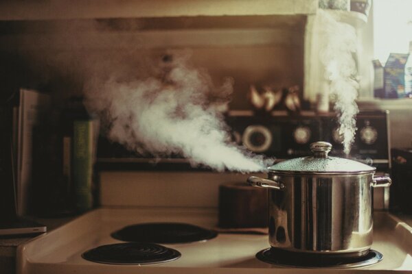 A pot of water is boiling in the kitchen