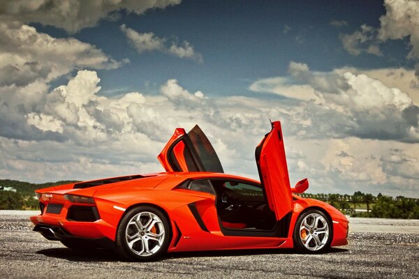 A sporty orange car against the sky