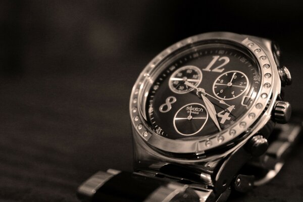 Silver watch with black dial on the table