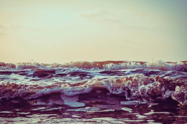 Coucher de soleil et vagues de l océan dans la mousse