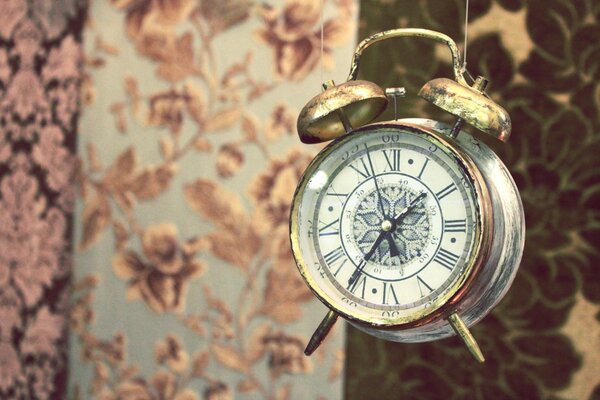 Vintage alarm clock on a background of different fabrics with a pattern