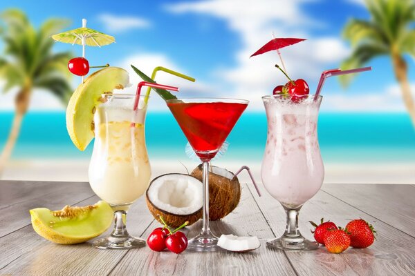 Three types of cocktails among palm trees on the sea