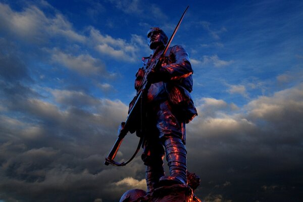 A man with a gun against a cloudy sky