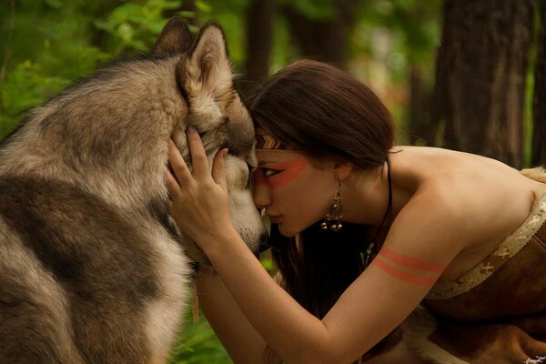 Chica abrazando a un lobo en el bosque