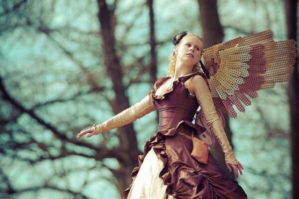 Beautiful girl with wings on the sky background