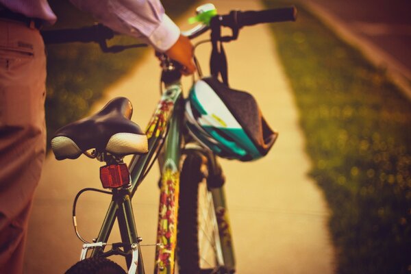 A man is carrying a bicycle with a helmet