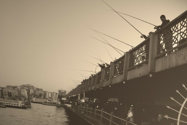 Pescadores pescando desde un puente en la ciudad