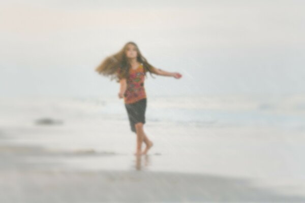 Fille qui court sur les vagues sur la plage